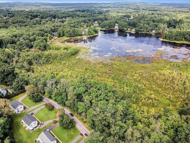 aerial view of property's location with a heavily wooded area and a nearby body of water
