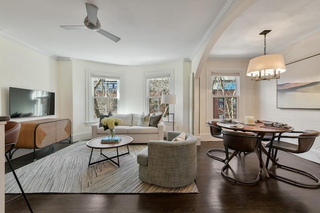 living room with crown molding, arched walkways, and a wealth of natural light