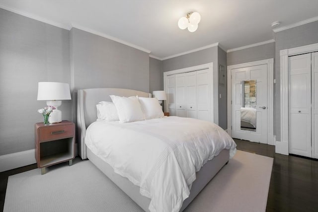 bedroom featuring baseboards, ornamental molding, and two closets