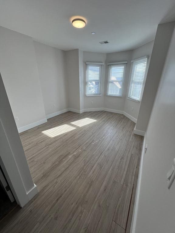 interior space featuring visible vents, baseboards, and wood finished floors