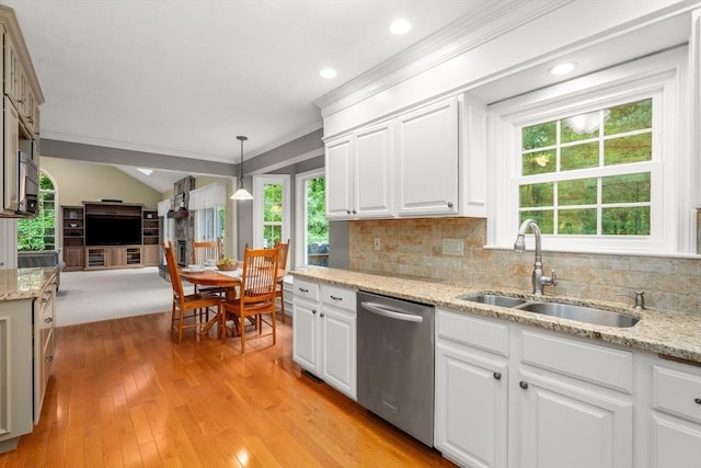 kitchen with stainless steel dishwasher, crown molding, a sink, tasteful backsplash, and light wood-style flooring