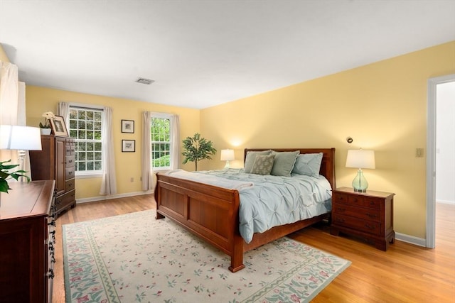 bedroom featuring light wood finished floors and baseboards