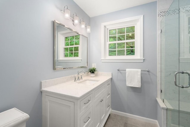 full bathroom with baseboards, a stall shower, vanity, toilet, and tile patterned floors