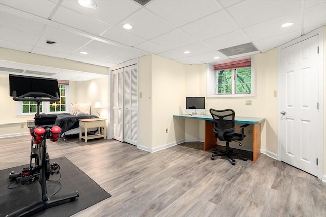 office area featuring wood finished floors, a paneled ceiling, and baseboards