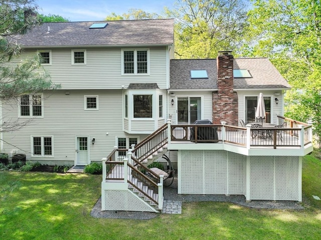 rear view of house featuring stairway, a yard, a deck, a chimney, and roof with shingles
