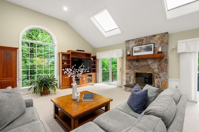 living room with a skylight, carpet, lofted ceiling, and a fireplace