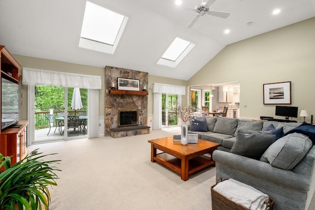 carpeted living room featuring a skylight, ceiling fan, a fireplace, high vaulted ceiling, and recessed lighting