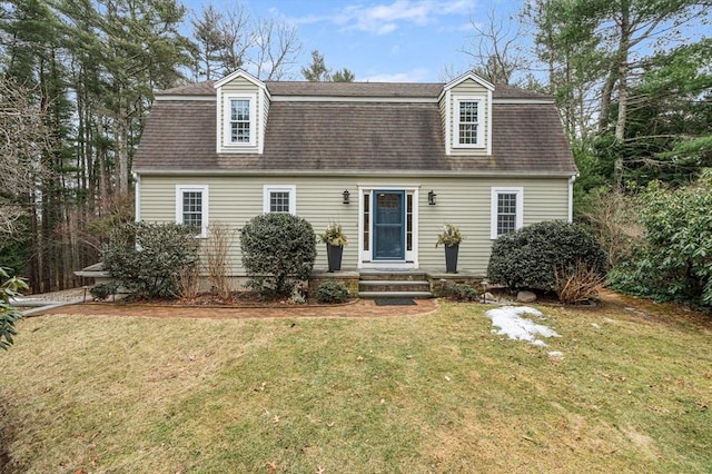 dutch colonial with a shingled roof, a front yard, and a gambrel roof