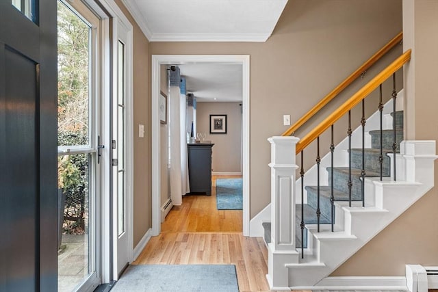 foyer with a baseboard heating unit, wood finished floors, baseboards, ornamental molding, and baseboard heating