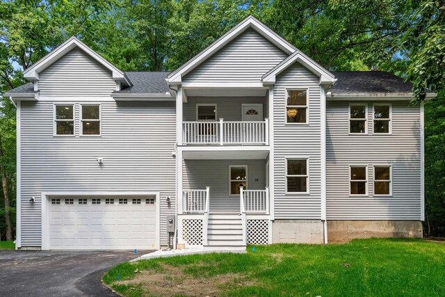 view of front of property with a balcony, a garage, and a front yard