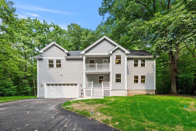 front of property featuring a balcony, a garage, and a front lawn