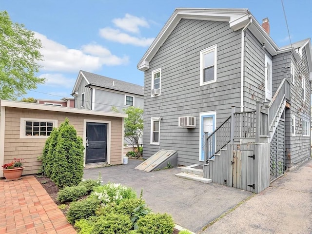 110 Reed St, Cambridge, MA 02140 - back of property with a chimney, a patio, a wall mounted AC, and stairs