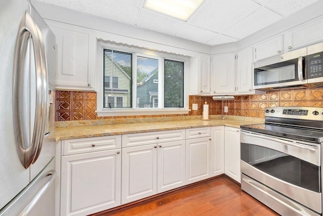 110 Reed St, Cambridge, MA 02140 - kitchen featuring appliances with stainless steel finishes, white cabinets, tasteful backsplash, and a paneled ceiling