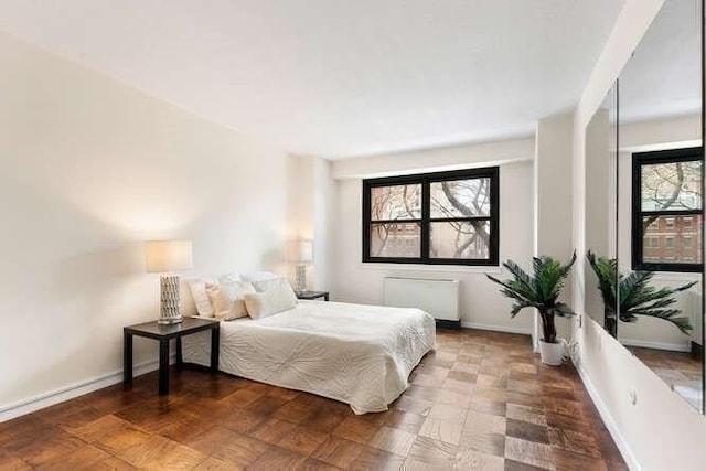 bedroom with baseboards and radiator heating unit