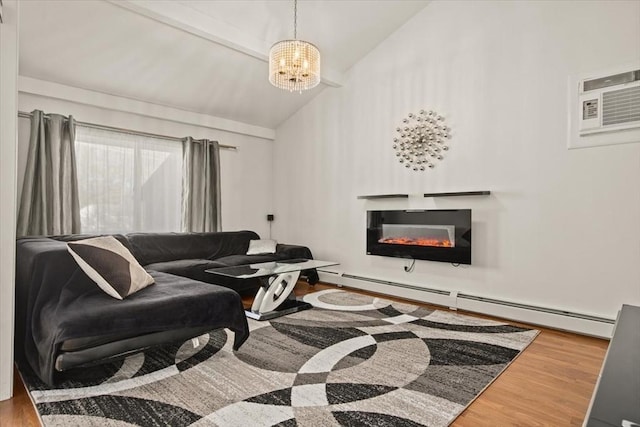 living room with wood finished floors, a glass covered fireplace, a baseboard heating unit, and a notable chandelier