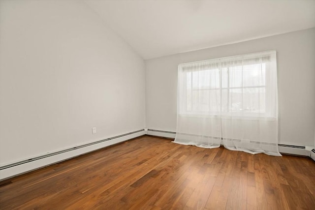 empty room with wood finished floors, lofted ceiling, and baseboard heating