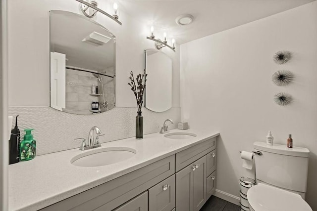 bathroom with double vanity, toilet, a sink, and a shower