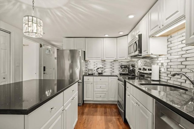 kitchen featuring a sink, decorative backsplash, white cabinets, and stainless steel appliances