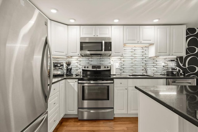 kitchen featuring a sink, appliances with stainless steel finishes, and white cabinets