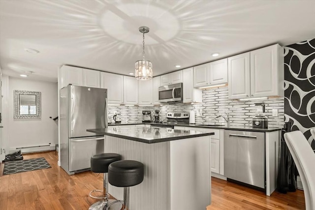 kitchen featuring a baseboard radiator, white cabinetry, appliances with stainless steel finishes, and dark countertops