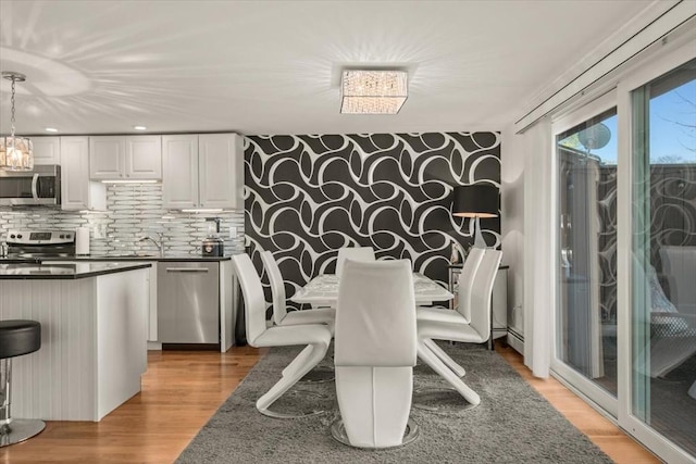 dining space featuring recessed lighting and light wood-style flooring