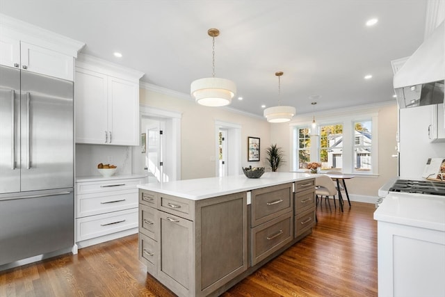 kitchen with white cabinets, built in fridge, dark wood-type flooring, and hanging light fixtures