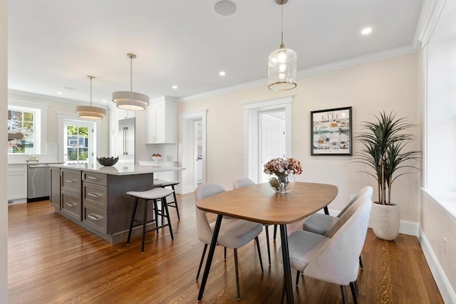 dining room with hardwood / wood-style flooring and crown molding