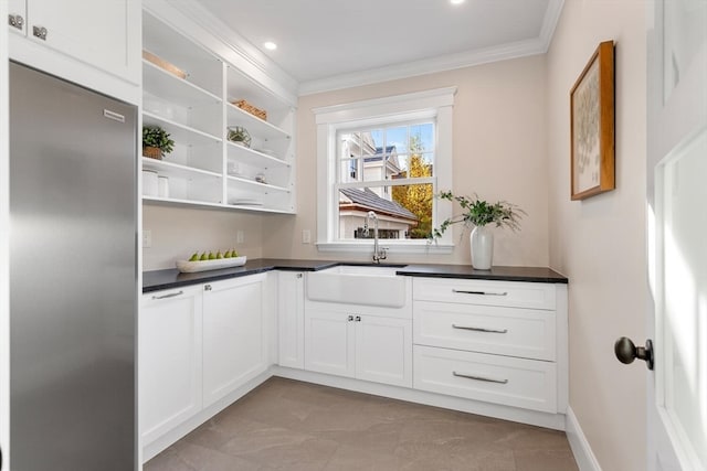 bar with white cabinets, ornamental molding, sink, and high end refrigerator