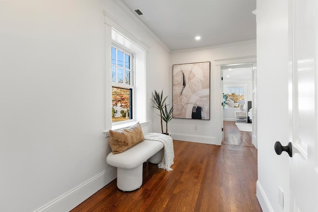 sitting room with ornamental molding and dark hardwood / wood-style floors