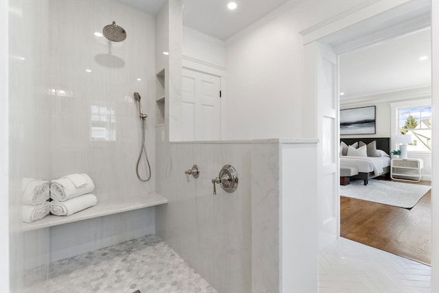 bathroom with hardwood / wood-style floors, tiled shower, and crown molding