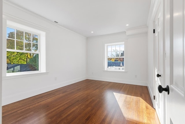 spare room featuring dark wood-type flooring and crown molding