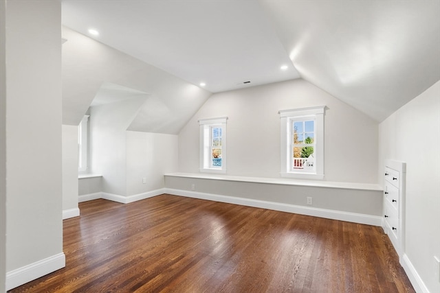 additional living space featuring dark wood-type flooring and lofted ceiling