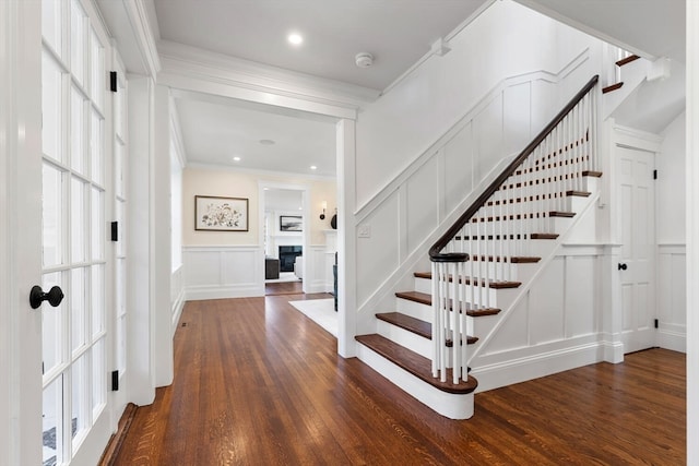 foyer entrance featuring dark wood-type flooring and crown molding