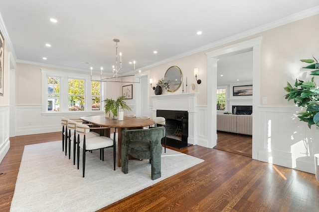 dining area featuring dark wood-type flooring, a chandelier, and ornamental molding