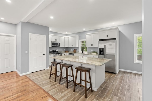 517 Primrose St, Haverhill, MA 01830 - kitchen featuring stainless steel appliances, light wood-style floors, a breakfast bar area, a center island, and recessed lighting