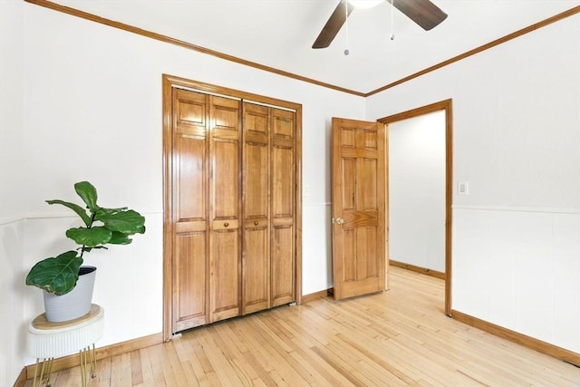 unfurnished bedroom featuring crown molding, baseboards, ceiling fan, and light wood finished floors