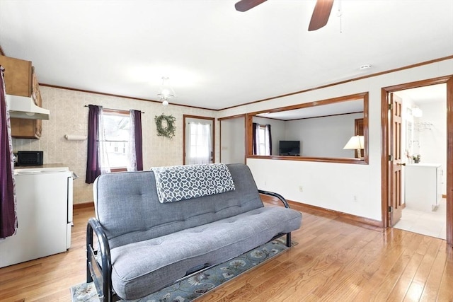 living room featuring crown molding, light wood finished floors, ceiling fan, and baseboards