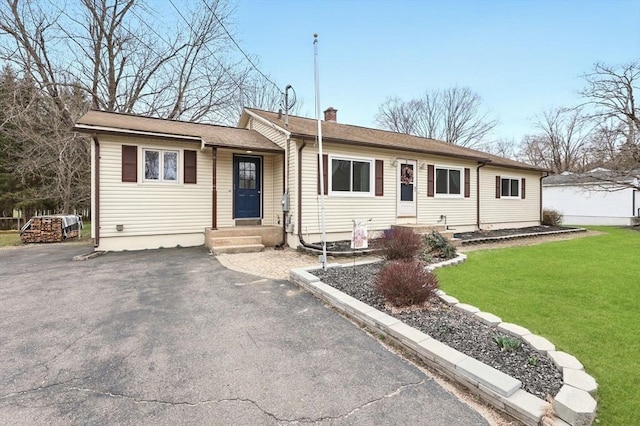 single story home with a chimney and a front lawn