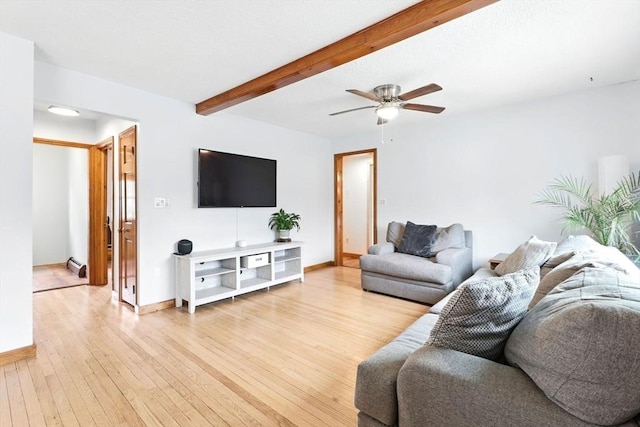 living area featuring baseboards, ceiling fan, beamed ceiling, and light wood-style flooring