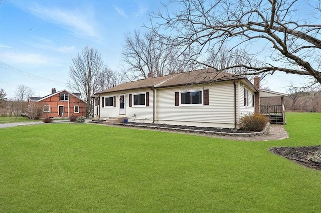 rear view of property with a yard and a chimney