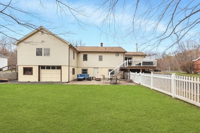 back of property featuring a fenced backyard, a wooden deck, an attached garage, and a yard