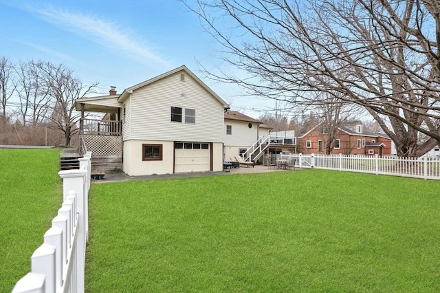rear view of property featuring stairway, a lawn, a fenced backyard, and a garage