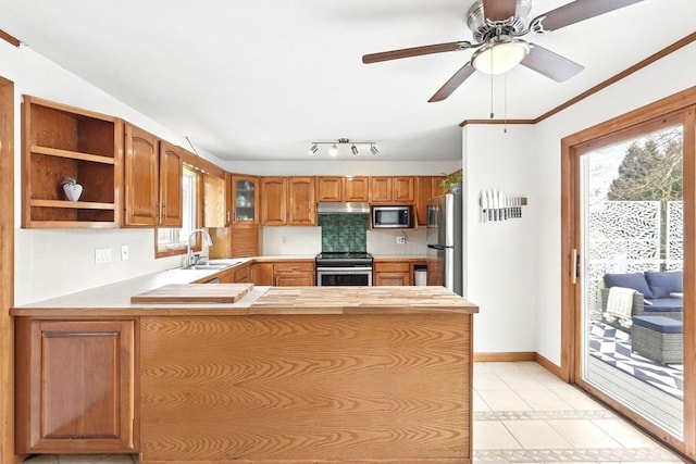 kitchen with a sink, stainless steel appliances, a peninsula, and a wealth of natural light