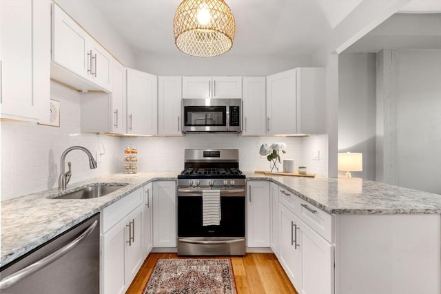 7 S Stone Mill Dr Unit 403, Dedham, MA 02026 - kitchen featuring stainless steel appliances, a sink, a peninsula, and white cabinetry