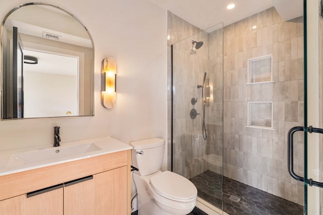 bathroom with vanity, toilet, and an enclosed shower