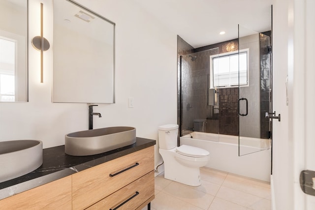 full bathroom featuring tile patterned floors, vanity, combined bath / shower with glass door, and toilet