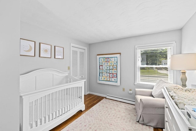 58 Spring St, Weymouth, MA 02188 - bedroom featuring a baseboard heating unit, wood finished floors, a closet, and baseboards