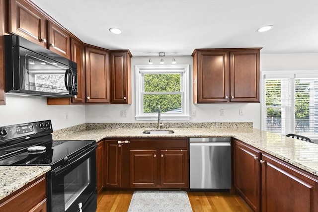 58 Spring St, Weymouth, MA 02188 - kitchen featuring black appliances, a sink, light wood-type flooring, light stone countertops, and recessed lighting