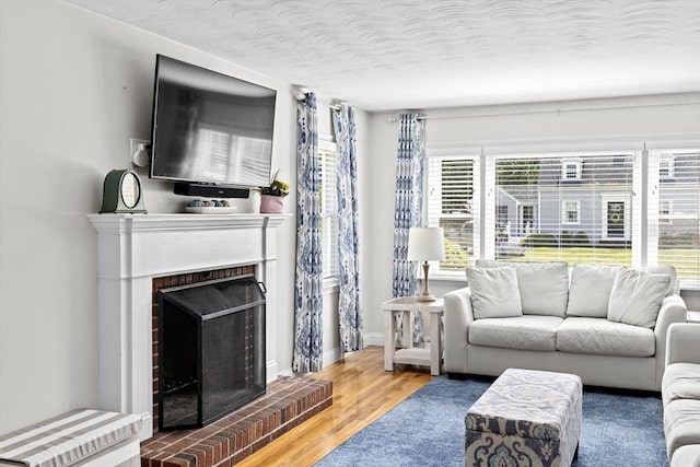 58 Spring St, Weymouth, MA 02188 - living area featuring wood finished floors, a brick fireplace, and baseboards