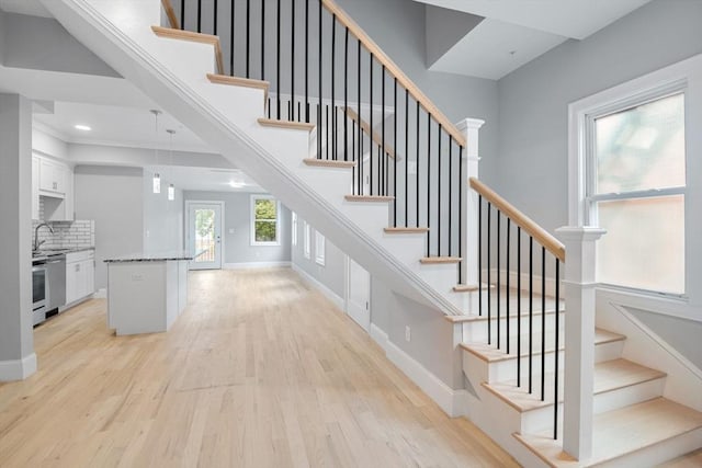 stairway featuring sink and hardwood / wood-style floors